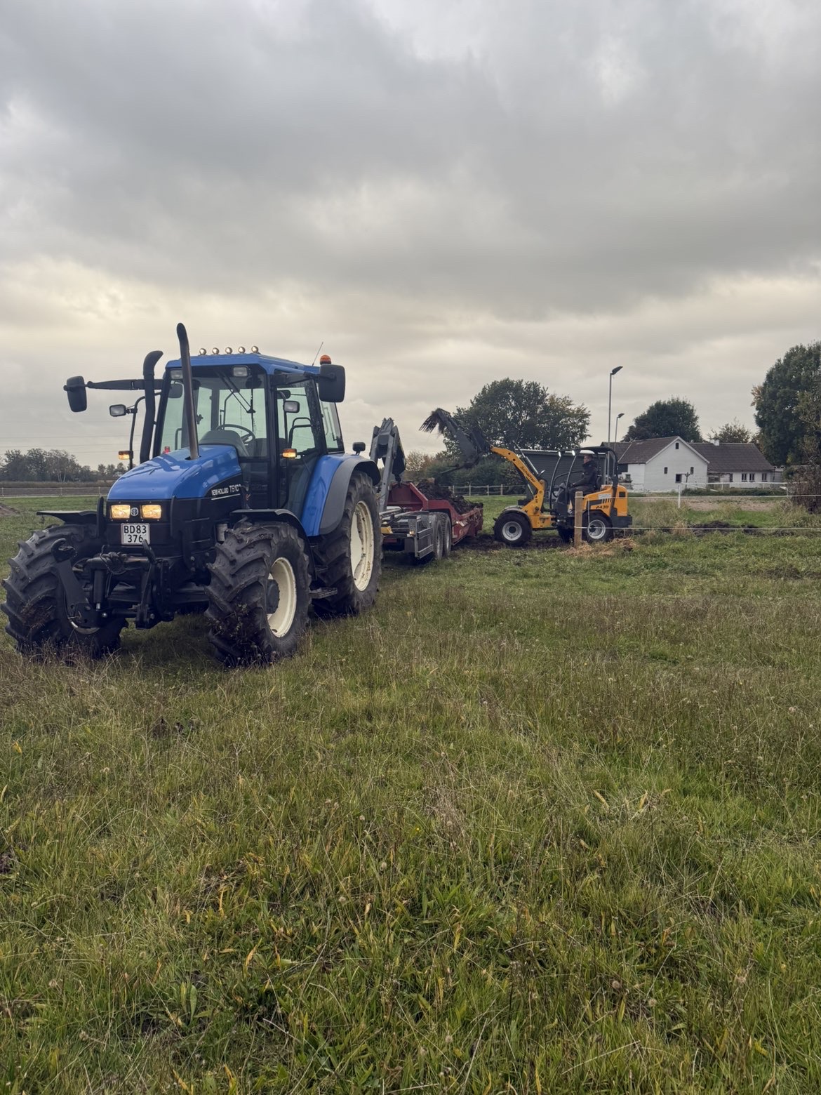 LC-Agro blå traktor med læssemaskine på mark